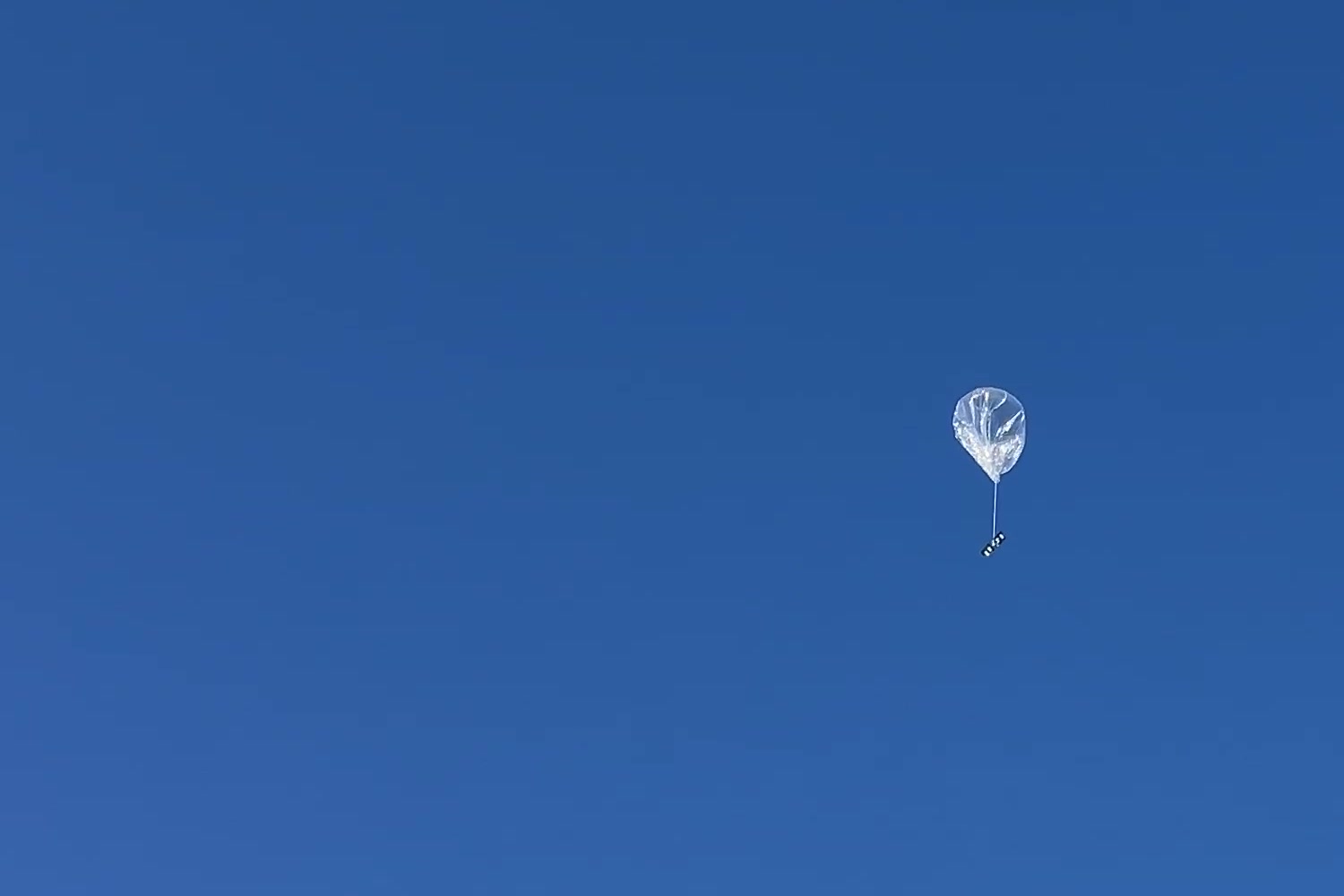 Stratolink 3 floating against a clear blue sky with its payload hanging beneath it.